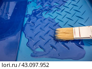 Белая кисть на синем фоне пластикового лотка. Инструмент штукатура-маляра/ One paint brush on a blue plastic tray with blue paint. Стоковое фото, фотограф Iva Noel / Фотобанк Лори