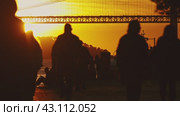 Silhouette of people walking in front of bridge at sunset. Стоковое видео, видеограф Константин Шишкин / Фотобанк Лори