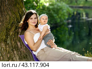 Woman with little child have rest in public park near pond. Стоковое фото, фотограф Владимир Григорьев / Фотобанк Лори