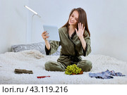 Web conference using tablet PC by happy woman who sits on bed indoors. Стоковое фото, фотограф Владимир Григорьев / Фотобанк Лори