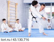 Male karate instructor training little child wearing kimono in dojo or jiu-jitsu in gym. Стоковое фото, фотограф Яков Филимонов / Фотобанк Лори