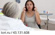 Positive young woman patient discussing face aesthetic procedures with a specialist in doctor's cabinet. Стоковое видео, видеограф Яков Филимонов / Фотобанк Лори