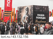 Exhibition of captured military equipment from the zone of the special military operation of the SVO on Poklonnaya Gora. A poster with the inscription in Russian: "Our victory is inevitable" and a crowd of people. Russia, Moscow, May 10, 2024. Редакционное фото, фотограф Photojuli / Фотобанк Лори