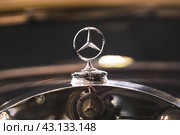 RUSSIA, MOSCOW - May 11, 2024: Close-up of the metal star of the Mercedes Benz logo on the hood of a retro car. Редакционное фото, фотограф Photojuli / Фотобанк Лори