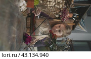 A woman creates a Florarium surrounded by dried flowers in her creative workshop (2024 год). Редакционное видео, видеограф Strunov David / Фотобанк Лори