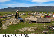 beautiful mature women sitting on a rock above the village of Tyulyuk against the backdrop of the Zigalga ridge in the Southern Urals. Стоковое фото, фотограф Акиньшин Владимир / Фотобанк Лори