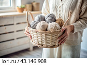 Close-up. A woman with balls of yarn in white and beige tones in her hands. Needlework, knitting. Winter season, small business, handmade clothes. Стоковое AI-изображение, AI-художник Photojuli / Фотобанк Лори