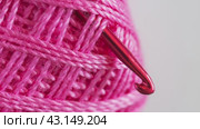 Video of skein of pink cotton yarn and metal crochet hook. Empty space for text on the left on white background. DIY concept. Crochet as a hobby. Flat lay,close-up, top view, macro. Стоковое видео, видеограф Виктория Катьянова / Фотобанк Лори