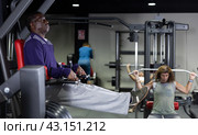African man doing leg raises on captains chair in gym. Стоковое фото, фотограф Яков Филимонов / Фотобанк Лори