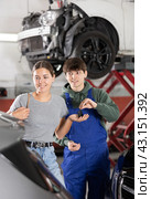 Young mechanic handing over remote key to female customer. Стоковое фото, фотограф Яков Филимонов / Фотобанк Лори