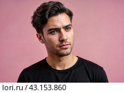 Dissatisfied young man looking unpleasantly away, expresses aversion, smirking at pink background. Guy in black t-shirt scared, negative face expressions concept. Advertising. Copy text space. Стоковое AI-изображение, AI-художник Aleksandr Golubev / Фотобанк Лори