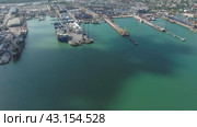 Industrial seaport, top view. Port cranes and cargo ships and barges. Loading and shipment of cargo at the port. View of the sea cargo port with a bird's eye view. Стоковое видео, видеограф Леонид Еремейчук / Фотобанк Лори