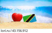 I love Tanzania and Zanzibar. Flag of Tanzania on the beach with a red heart. vacation and travel concept. (2023 год). Стоковое фото, фотограф Никита Бурденков / Фотобанк Лори