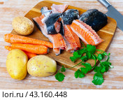 Salmon offal served with vegetables on board. Стоковое фото, фотограф Яков Филимонов / Фотобанк Лори