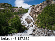 View of the Alibek waterfall formed by the fall of the Jalovchatka River from the Alibek glacier on a sunny summer day, Dombay, Karachay-Cherkessia, Russia. Стоковое фото, фотограф Ula Ulachka / Фотобанк Лори