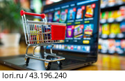 Shopping Cart on Top of Laptop Computer. Стоковое AI-изображение, AI-художник Юлия Гапеенко / Фотобанк Лори