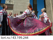 Девушки в русских национальных костюмах водят хороводы и поют народные песни у арки Центрального входа на территорию выставочного комплекса ВДНХ в городе Москве, Россия (2024 год). Редакционное фото, фотограф Николай Винокуров / Фотобанк Лори