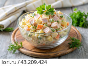 Traditional Russian Olivier salad for a feast on a plate on a wooden countertop. generative AI. Стоковое AI-изображение, AI-художник Photojuli / Фотобанк Лори