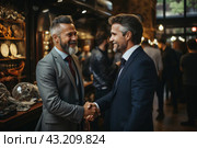 Two men in business suits shake hands and smile. Both men appear mature and have gray hair and beards. The scene takes place in what appears to be a museum or exhibition hall, with various exhibits and other people in the background. The atmosphere is businesslike and friendly, giving the impression that the men have concluded a successful deal or reached an important agreement. Стоковое AI-изображение, AI-художник Анна Кривицкая / Фотобанк Лори