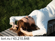 Headshot portrait of happy young woman outdoors. Teenager student girl smiling, turning her head in the sun, enjoying the weather with closed eyes. Millennial blonde girl relaxing in park, close-up. Стоковое фото, фотограф Вербицкая Светлана / Фотобанк Лори