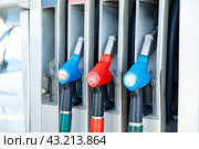 Fuel pistols close up at the gas station. Concept of transportation, energy crisis, oil crisis. Full tank in the midst of a price crisis at the gas pump. Стоковое фото, фотограф Ирина Михайличенко / Фотобанк Лори