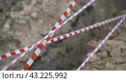 Red white barrier tape trenches. Focus on red and white barrier tape at construction site. Ribbons indicate dug trenches. Стоковое фото, фотограф svetograph / Фотобанк Лори