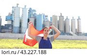 Sad young woman worker standing with big flag of Austria against background of factory. Стоковое видео, видеограф Яков Филимонов / Фотобанк Лори