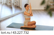 Calm european young female gym trainer practicing advanced yoga, variations of half lord pose or Ardha Matsyendrasana during yoga training in yoga studio. Стоковое видео, видеограф Яков Филимонов / Фотобанк Лори