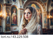 Portrait of a beautiful young woman in a headscarf in an Orthodox church. A girl prays in a church against the background of icons. Стоковое AI-изображение, AI-художник Photojuli / Фотобанк Лори