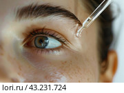 Young woman applying serum on her face. Caucasian 20s girl holding dropper skin care product. Female applies essential oil with oily pipette. Advertising facial care cosmetics. Health, youth. Serums. Стоковое AI-изображение, AI-художник Марина Демидюк / Фотобанк Лори