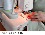 Швея шьёт на профессиональной швейной машинке одежду, крупный план. A seamstress sews clothes on a professional sewing machine, close-up. Стоковое фото, фотограф Наталья Пеньшина / Фотобанк Лори