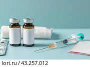 Syringe and glass vial on blue background table. Medical Vials group, needles, ampoules, bottle with medicines or vaccine. Disease treatment. Creative Banner. Anti-aging beauty injections. Vaccination. Стоковое AI-изображение, AI-художник Марина Демидюк / Фотобанк Лори