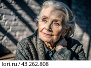 Minimalism. A studio portrait of a stylish, elegant elderly woman, a pensioner of 70 years old, in an interior and clothes of calm tones. The concept of the elderly. Стоковое AI-изображение, AI-художник Photojuli / Фотобанк Лори