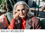 Minimalism. A studio portrait of a stylish, elegant elderly woman, a pensioner of 70 years old, in an interior and clothes of calm tones. The concept of the elderly. Стоковое AI-изображение, AI-художник Photojuli / Фотобанк Лори
