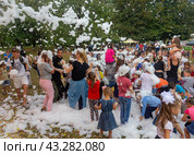 Kamennomostsky, Russia - September 1, 2018: Happy children having fun at a foam party at a holiday town day in an autumn park. Редакционное фото, фотограф Андрей С / Фотобанк Лори