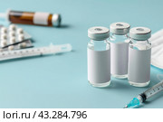 Syringe and glass vial on blue background table. Medical Vials group, needles, ampoules, bottle with medicines or vaccine. Disease treatment. Creative Banner. Anti-aging beauty injections. Vaccination. Стоковое AI-изображение, AI-художник Марина Демидюк / Фотобанк Лори