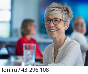 Smiling Woman with Short Hair and Glasses in a Meeting. Стоковое AI-изображение, AI-художник Кирилл Черезов / Фотобанк Лори