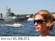Портрет молодой девушки в солнечных очках на фоне Военных кораблей стоящих на рейде в акватории реки Невы. Военно-морской парад в Санкт-Петербурге на день ВМФ. (2014 год). Редакционное фото, фотограф Константин Сергеевич Синявин / Фотобанк Лори