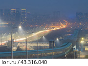 Ночной городской пейзаж. Вид на большой город в сумерках. На переднем плане метромост. Вдали автомобильный мост через реку Обь и многоэтажные здания. Город Новосибирск, Новосибирская область, Сибирь, Россия. Стоковое фото, фотограф Андрей Степанов / Фотобанк Лори