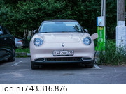 Electric car GWM ORA 03 parked on street and charging (2024 год). Редакционное фото, фотограф Константин Григорьев / Фотобанк Лори