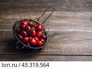 Спелая сочная черешня в дуршлаге на старом деревянном столе. Фрукты и ягоды. Малая глубина резкости. Стоковое фото, фотограф Андрей Пустякин / Фотобанк Лори