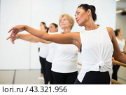 Portrait of an asian woman standing in the 2nd position of the ballet stance near the ballet barre. Стоковое фото, фотограф Яков Филимонов / Фотобанк Лори