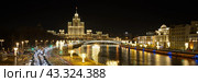 Москва, Россия. Ночной вид на Москву-реку и высотное здание на Котельнической набережной. Красивое освещение зданий и набережных. Вечерний городской пейзаж. Широкая панорама. Стоковое фото, фотограф Андрей Степанов / Фотобанк Лори