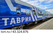 Синий поезд «Таврия» у железнодорожной платформы (2024 год). Редакционное фото, фотограф Ирина Терентьева / Фотобанк Лори