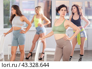 Group of girls unleash their energy and dance passionately near a chair in high heels in a dance studio. His powerful moves combined with elegance of high heels. Стоковое фото, фотограф Яков Филимонов / Фотобанк Лори