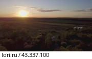 Breathtaking sunset view over green fields and forests, creating a serene atmosphere. Стоковое видео, видеограф Victor Kaprov / Фотобанк Лори