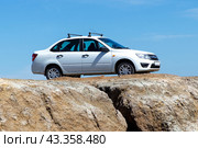 Russian car Lada Granta on on cliff of the canyon (2024 год). Редакционное фото, фотограф Евгений Ткачёв / Фотобанк Лори