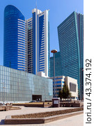 Blue highrise glass skyscraper street low angle shot. Modern high-rise buildings and an empire style house on a sunny day. Astana. Republic of Kazakhstan. Стоковое фото, фотограф Евгений Ткачёв / Фотобанк Лори