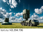 Modern air defence radar of military mobile missile launcher system of green color at blue cloudy sky background. Air defense installation outdoors. Concept of modern army industry. Copy ad text space. Стоковое AI-изображение, AI-художник Aleksandr Golubev / Фотобанк Лори