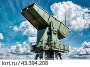 Modern air defence radar of military mobile missile launcher system of green color at blue cloudy sky background. Air defense installation outdoors. Concept of modern army industry. Copy ad text space. Стоковое AI-изображение, AI-художник Aleksandr Golubev / Фотобанк Лори